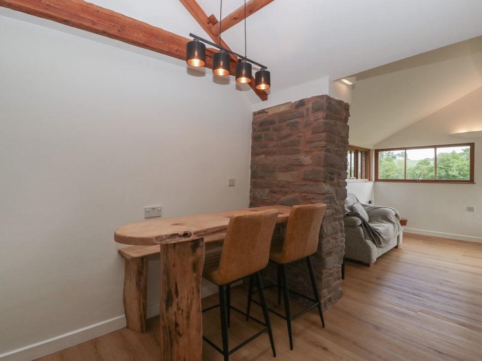 A living room with a bar counter and stools at Ynys in Pandy near Ewyas Harold