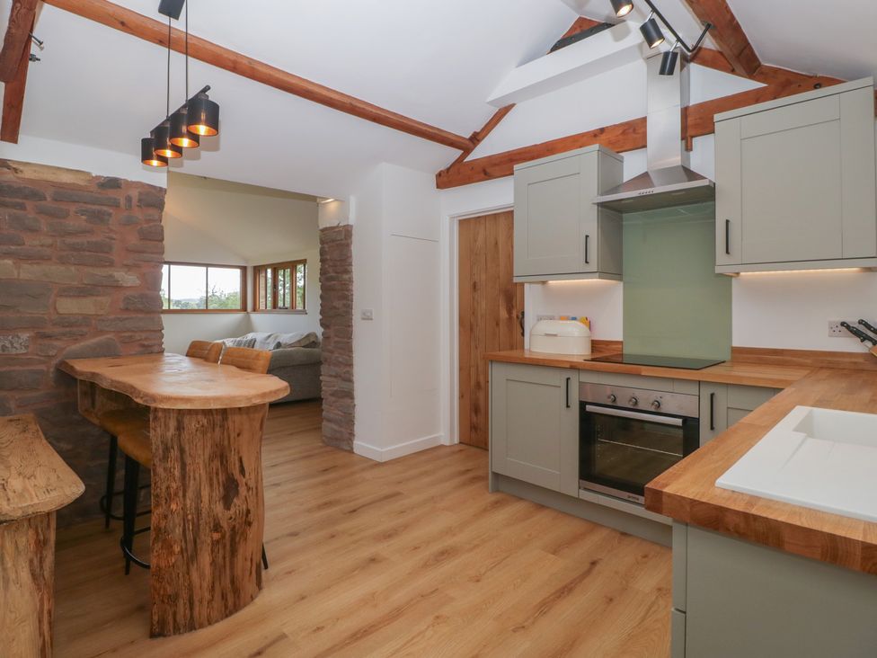A kitchen with wood countertops and a bar counter at Ynys Pandy near Ewyas Harold