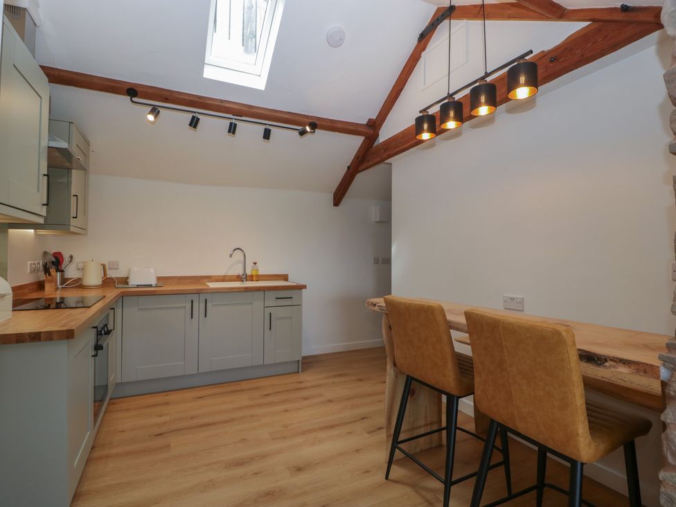 A kitchen with cabinets and bar stools at Ynys in Pandy near Ewyas Harold