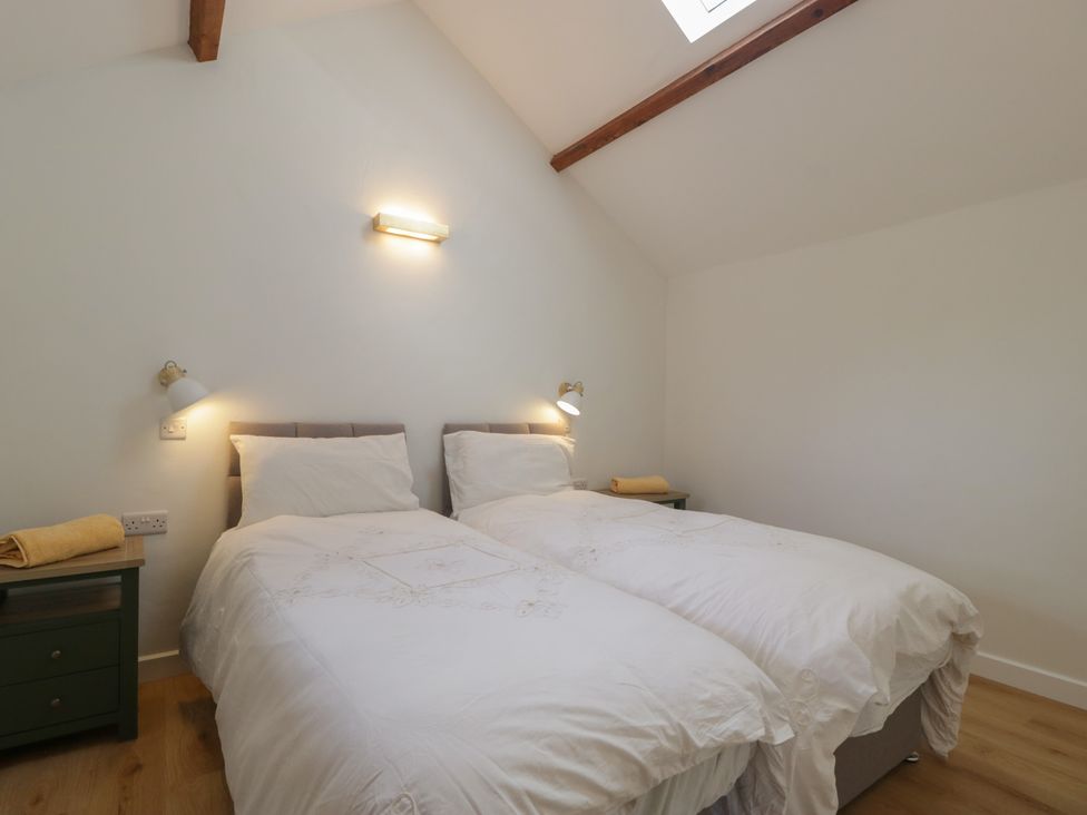 A bedroom with two beds and bedside lamps at Ynys Pandy near Ewyas Harold