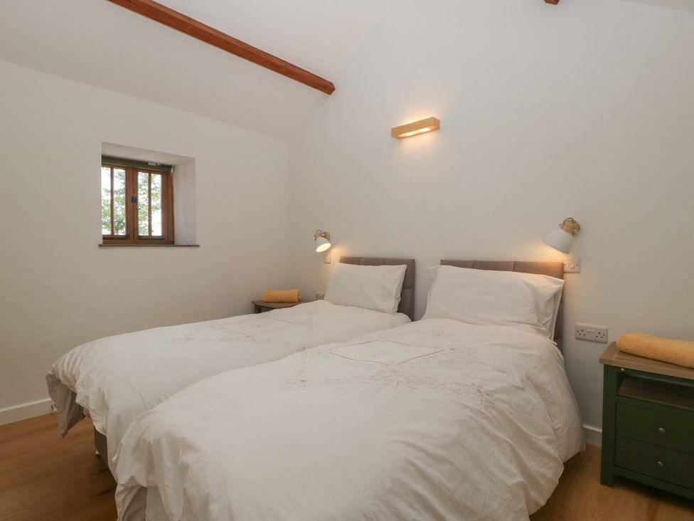 A bedroom with twin beds and a window at Ynys Pandy near Ewyas Harold