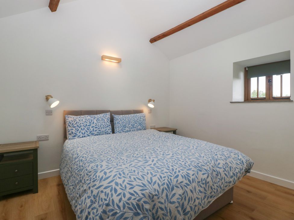 A bedroom with a bed and lamps at Ynys Pandy near Ewyas Harold