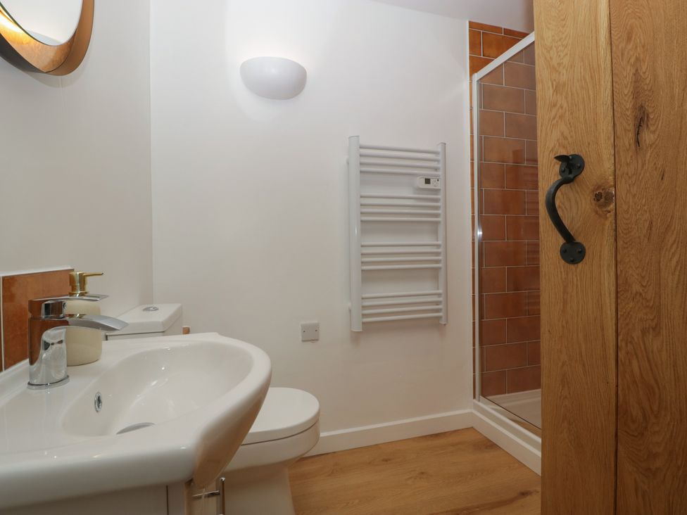 A bathroom with a sink, shower, and toilet at Ynys Pandy near Ewyas Harold