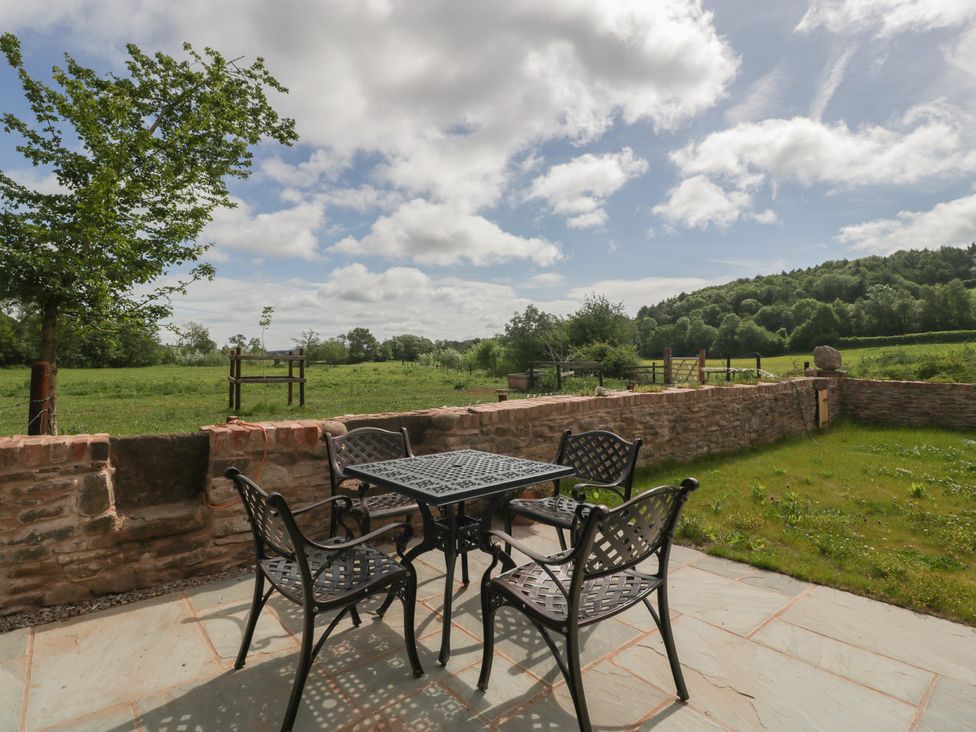 An outdoor seating area with a table and chairs at Ynys Pandy near Ewyas Harold