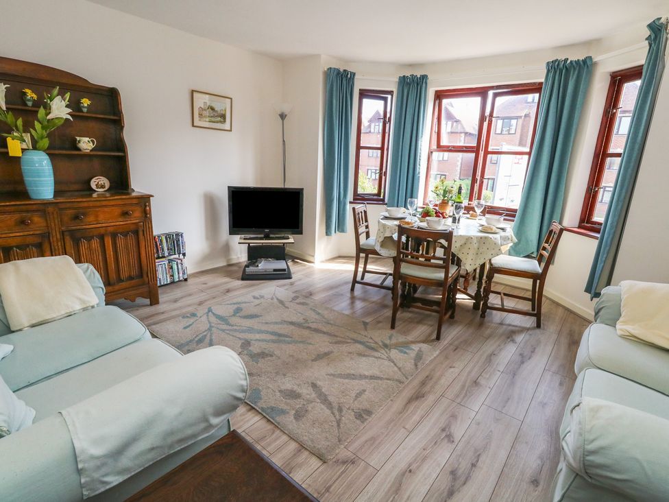 A living room with a dining area and television at Flat 9 in Swanage