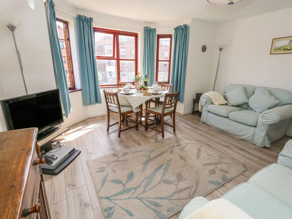A living room with a table set for dining at Flat 9 in Swanage