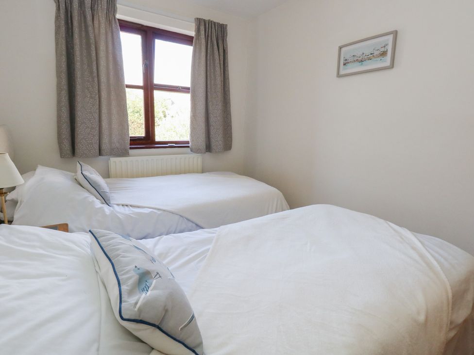 A bedroom with two beds and a window at Flat 9 in Swanage