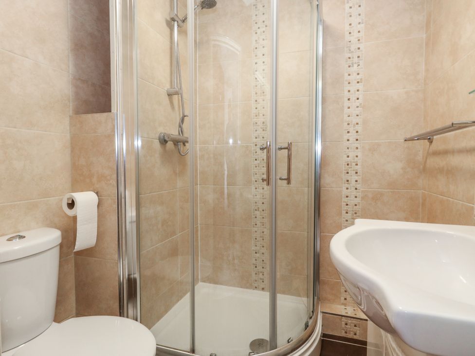 A bathroom with a shower, sink, and toilet at Flat 9 in Swanage