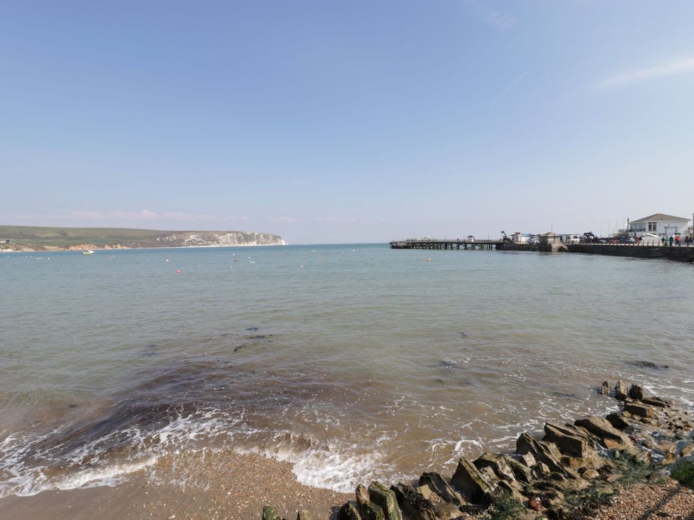 A view of the sea and pier with cliffs in the background at Flat 9 in Swanage