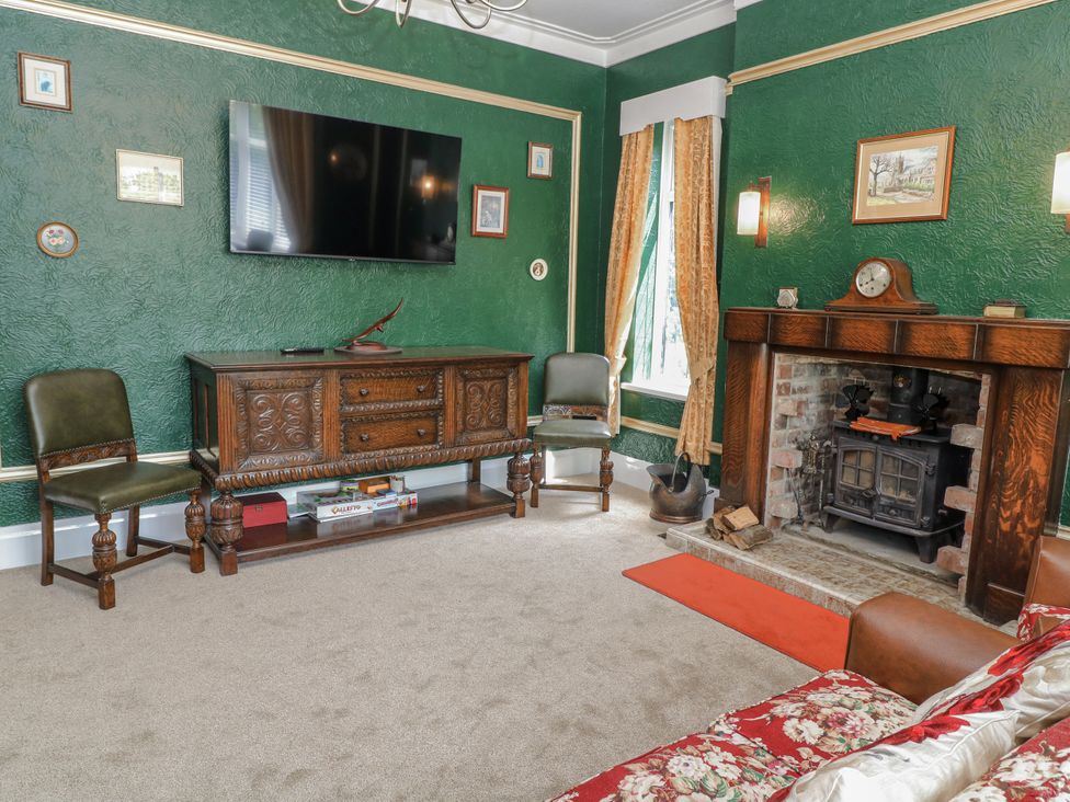 A living room with a television and sideboard at Bentfield House Rotherham near Whiston