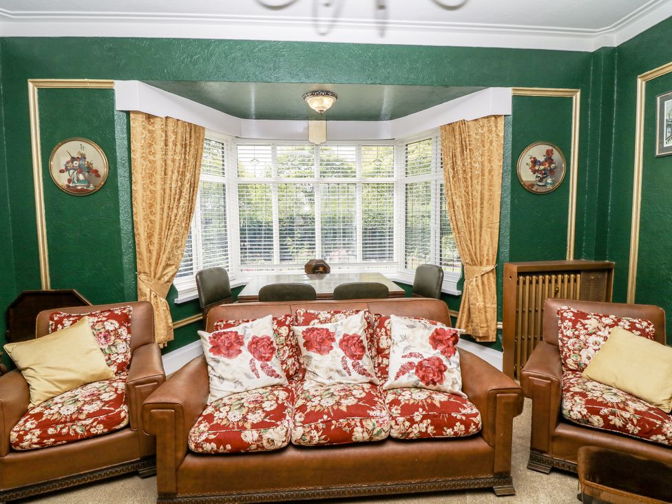 A living room with floral sofas and curtains at Bentfield House in Rotherham near Whiston