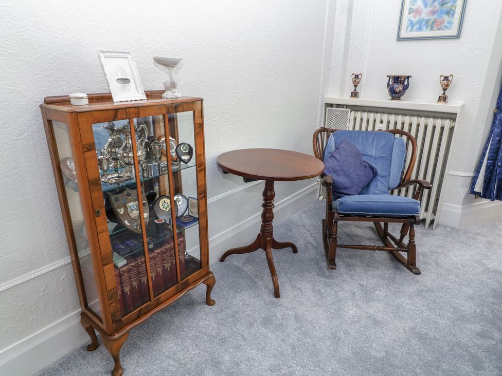 A living room with a display cabinet and rocking chair at Bentfield House Rotherham near Whiston