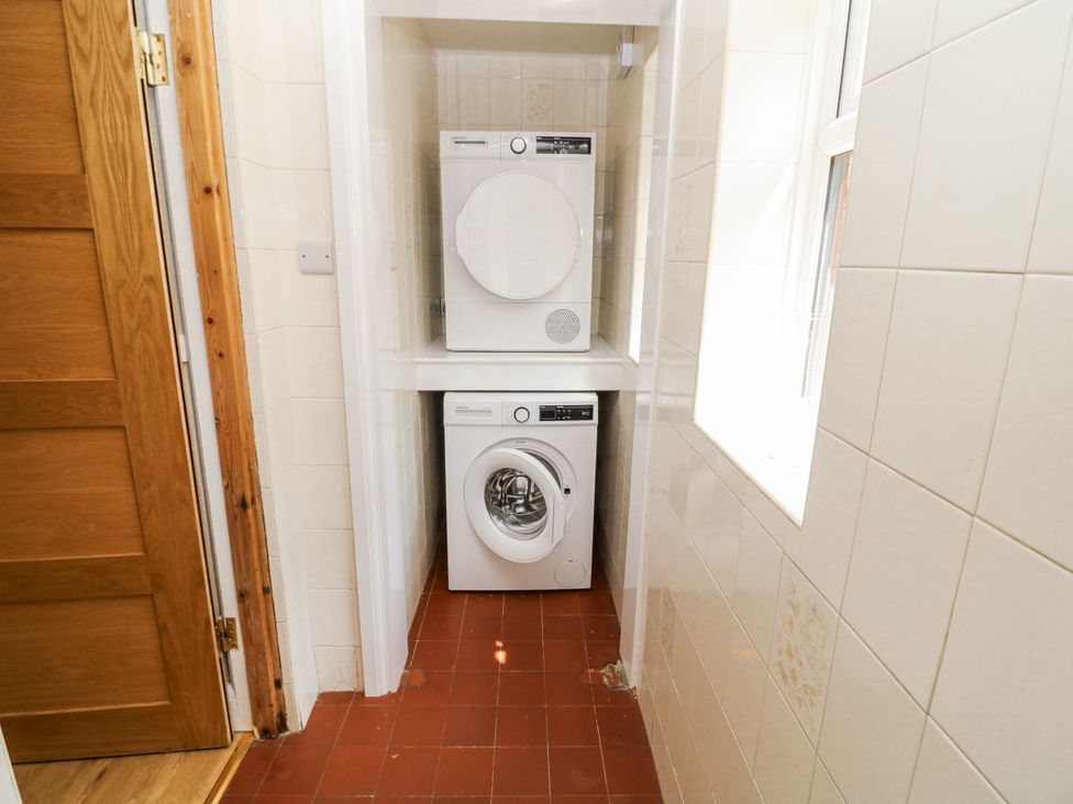 A laundry room with a washing machine and a tumble dryer at Bentfield House Rotherham near Whiston