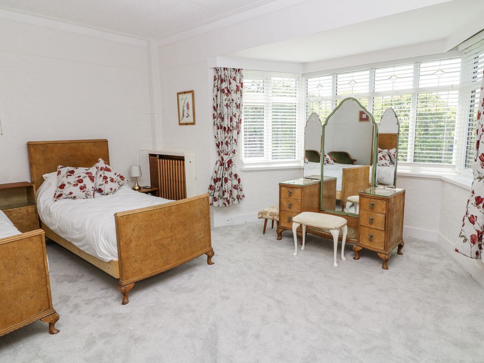 A bedroom with two beds and a vanity table at Bentfield House in Rotherham near Whiston