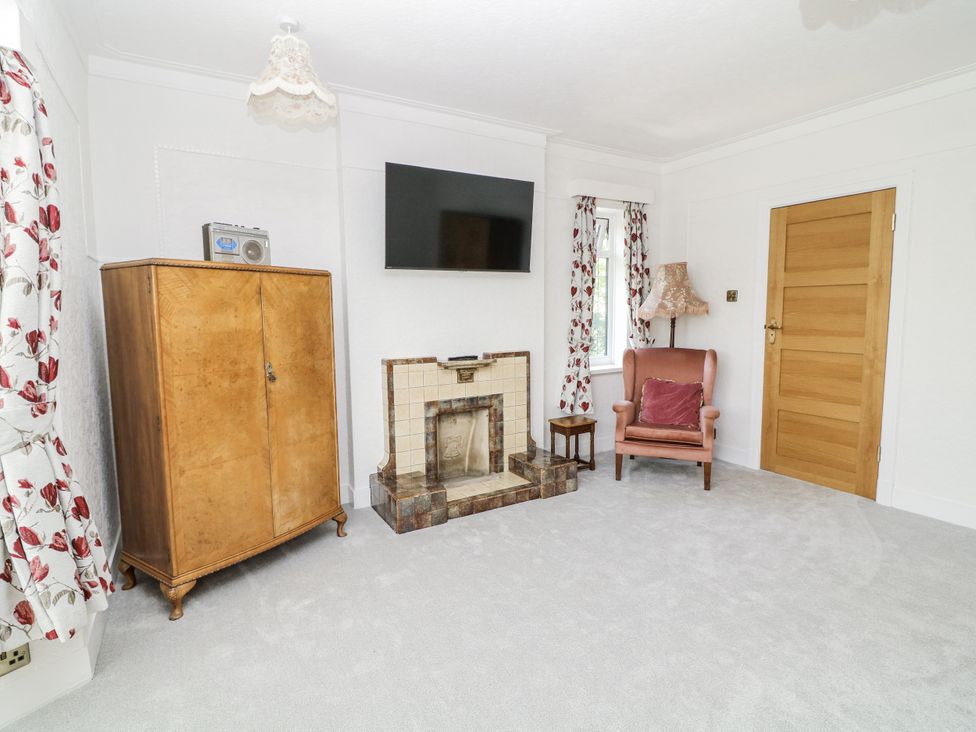 A living room with an armchair and a fireplace at Bentfield House Rotherham near Whiston