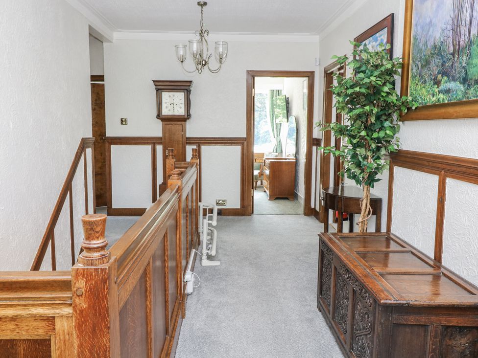 A hallway with wooden furniture and a clock at Bentfield House in Rotherham near Whiston