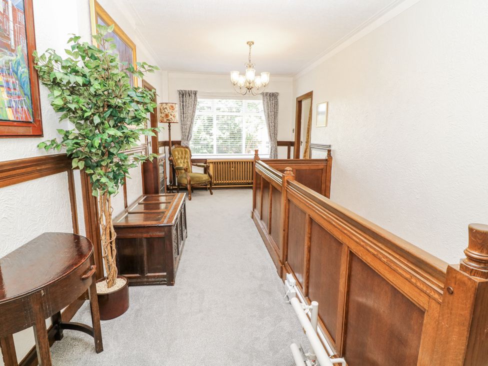 A hallway with a plant and chair at Bentfield House Rotherham near Whiston