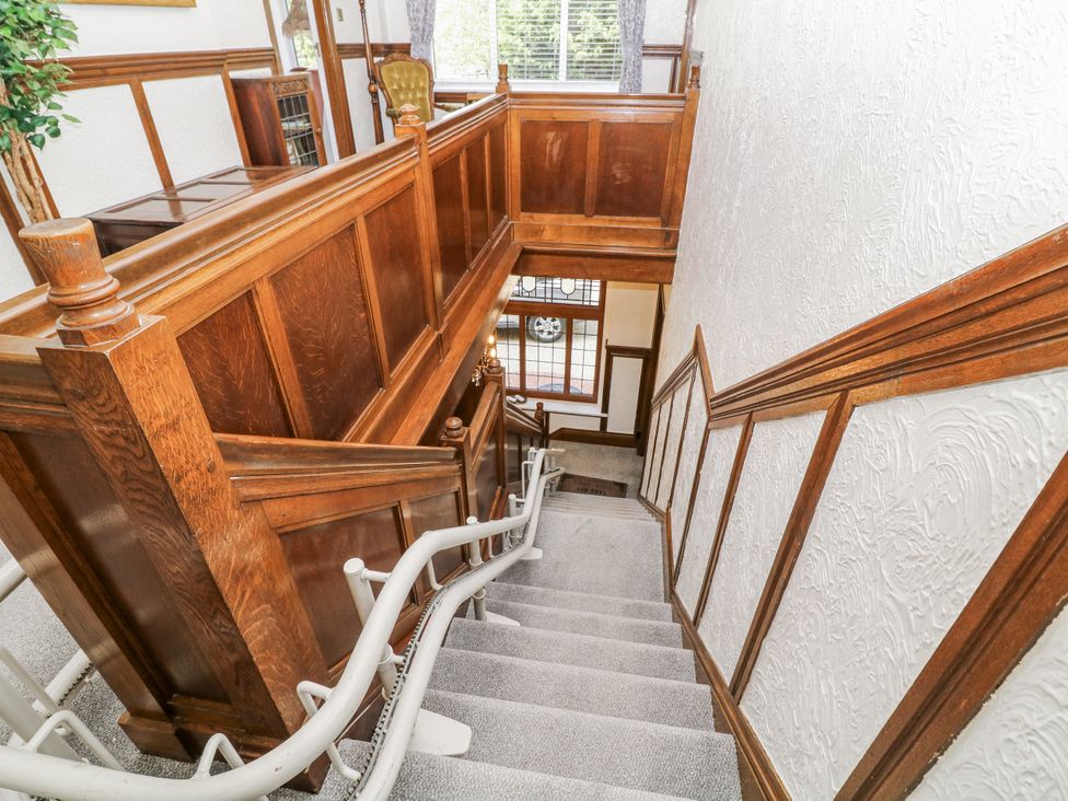 A staircase with wooden paneling and a handrail at Bentfield House in Rotherham near Whiston