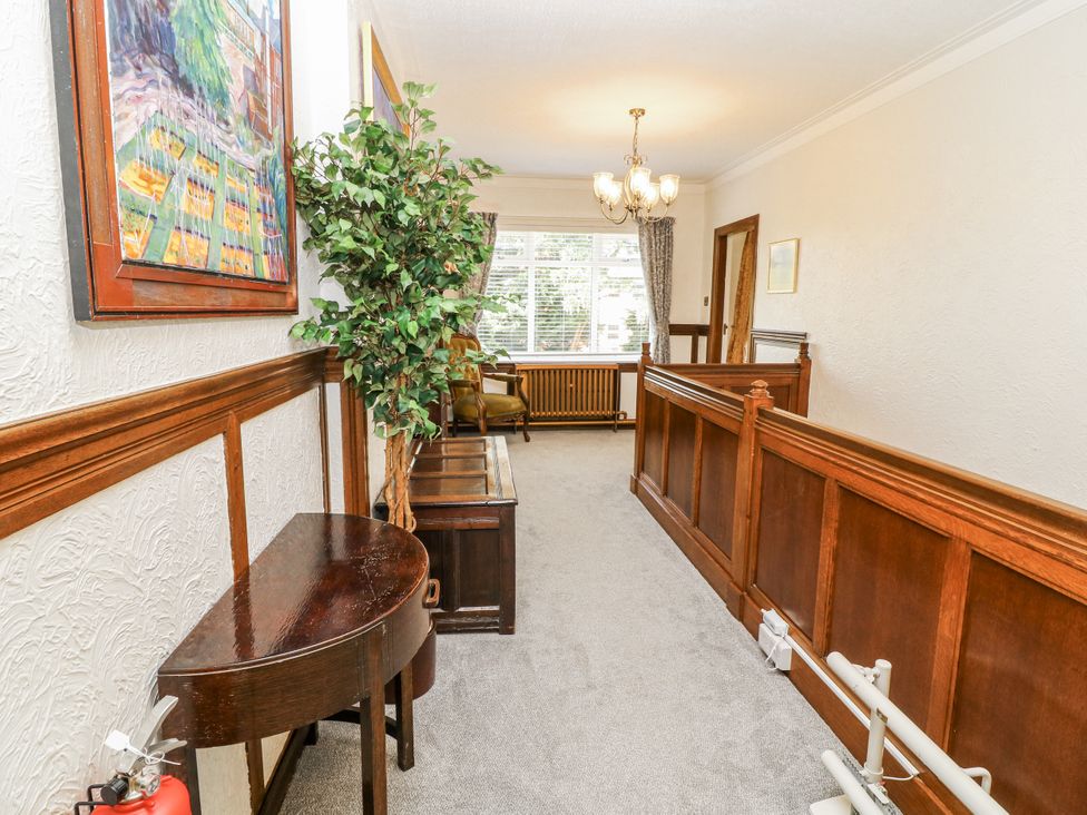 A hallway with a potted plant and a painting at Bentfield House in Rotherham near Whiston