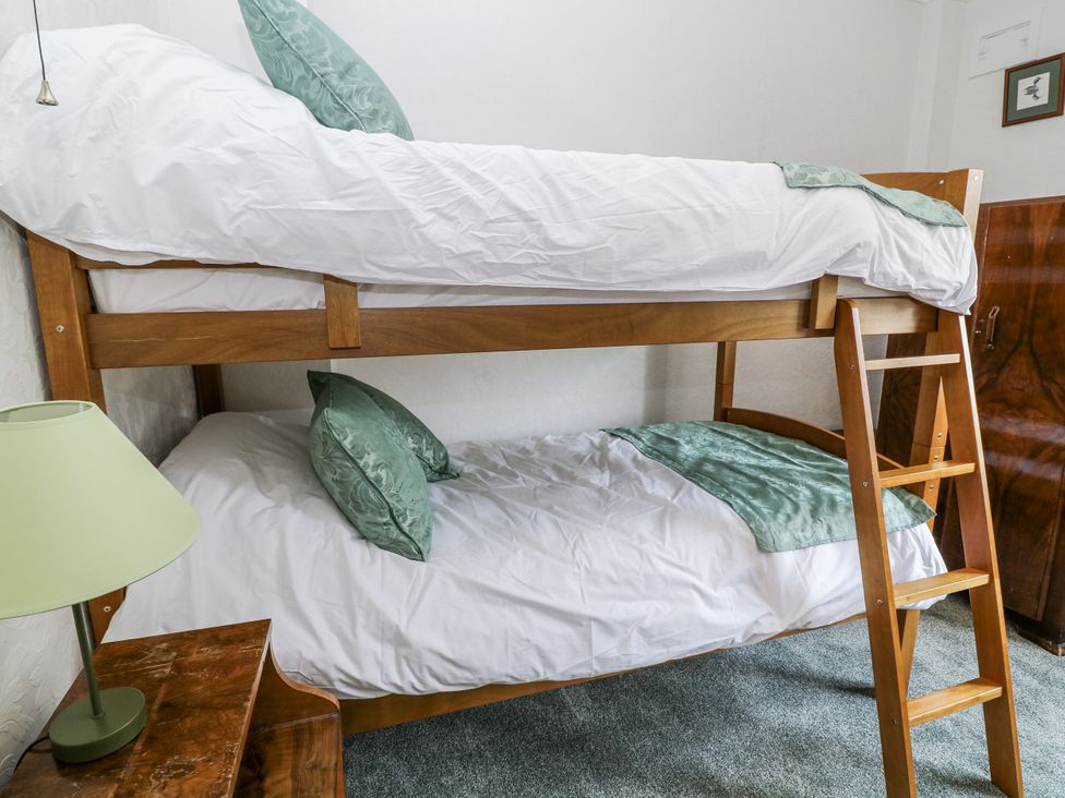 A bunk bed with a green pillow and a lamp at Bentfield House in Rotherham near Whiston