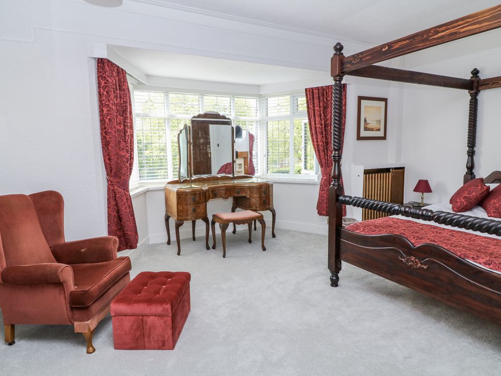 A bedroom with a four-poster bed and dressing table at Bentfield House in Rotherham near Whiston