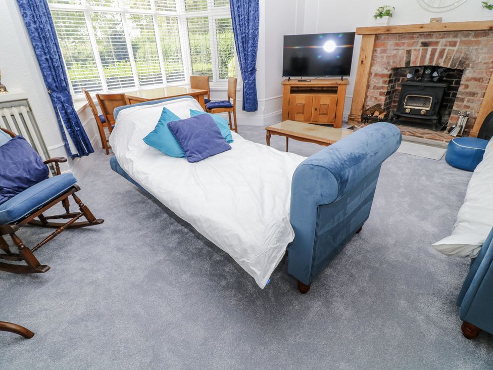 A living room with a sofa and rocking chair at Bentfield House Rotherham near Whiston