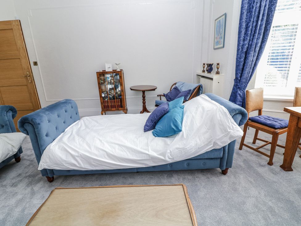 A living room with a blue sofa and wooden table at Bentfield House in Rotherham near Whiston