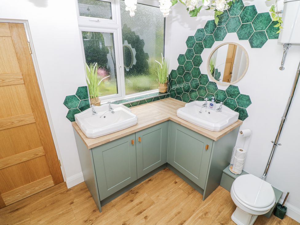 A bathroom with dual sinks and a toilet at Bentfield House Rotherham near Whiston