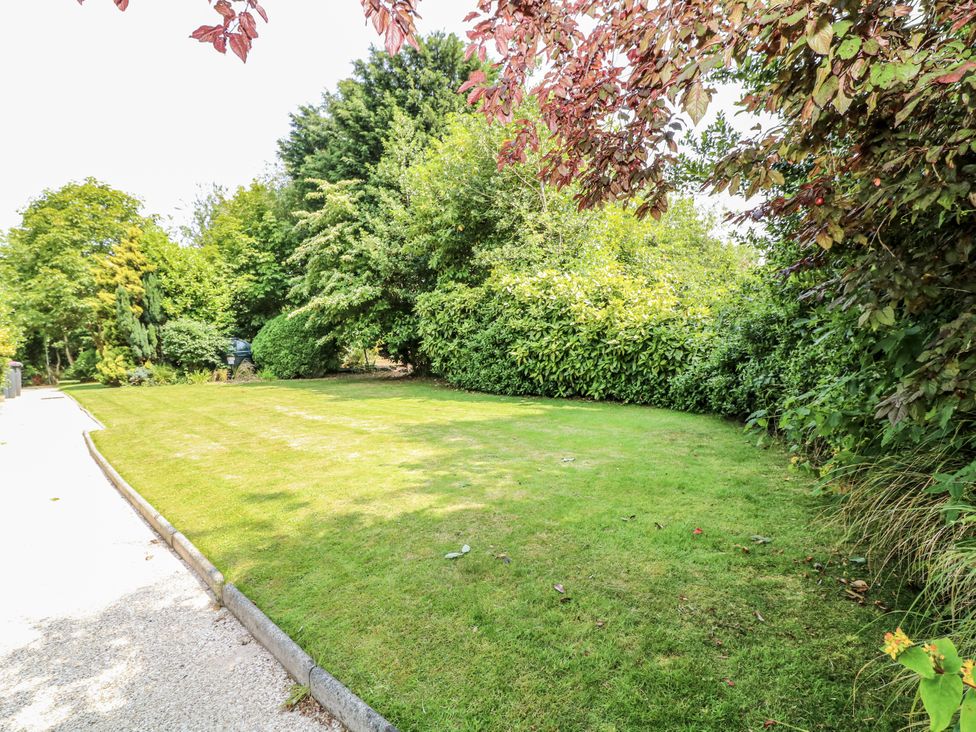 A garden with grass and various bushes at Bentfield House in Rotherham near Whiston