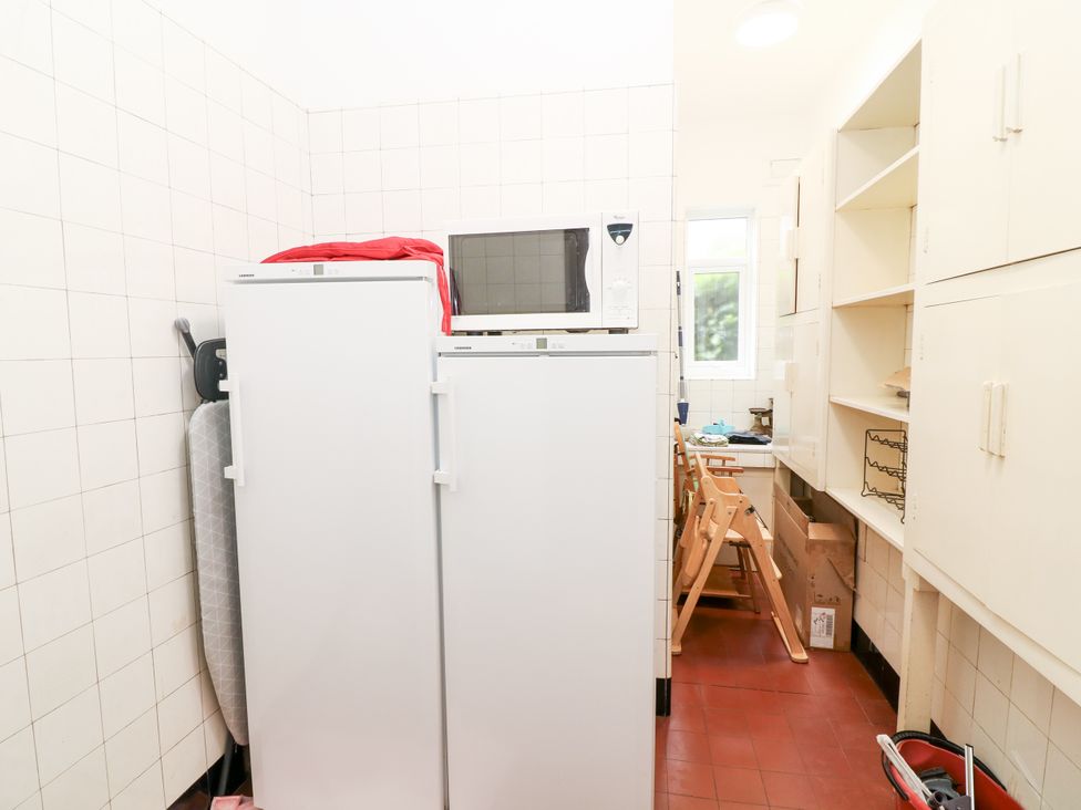 A kitchen with a refrigerator, microwave, and cabinets at Bentfield House in Rotherham near Whiston