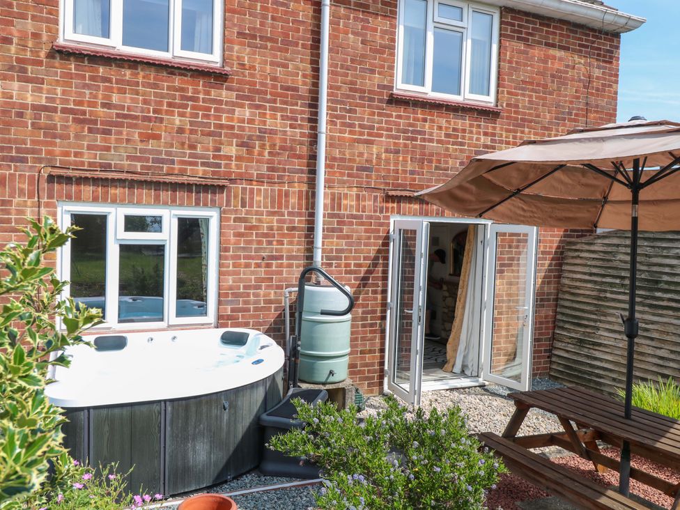 A garden with a hot tub and patio table at 3 Birkbeck Way Norwich