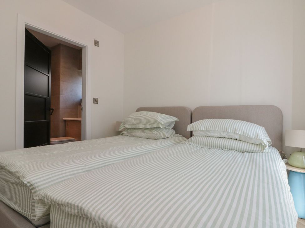 A bedroom with twin beds and an adjoining bathroom at 12 Gap Road, Filey