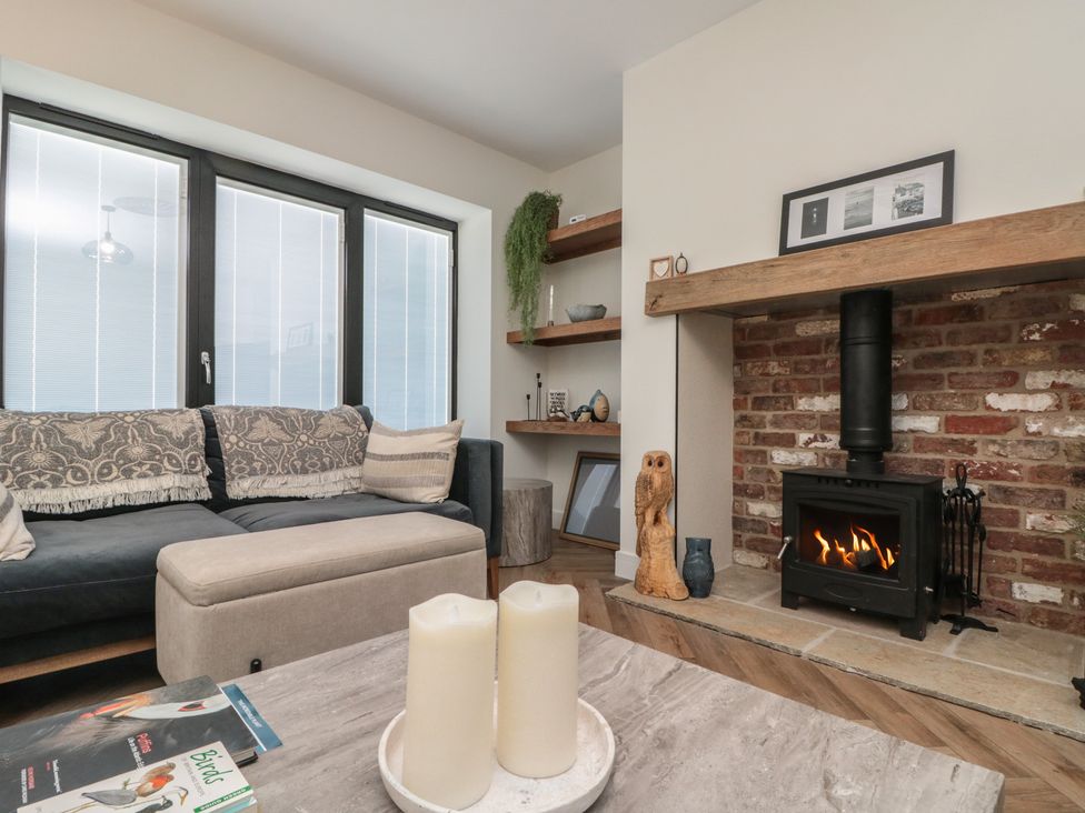 A living room with a sofa and fireplace at Puffin Lodge in Hunmanby