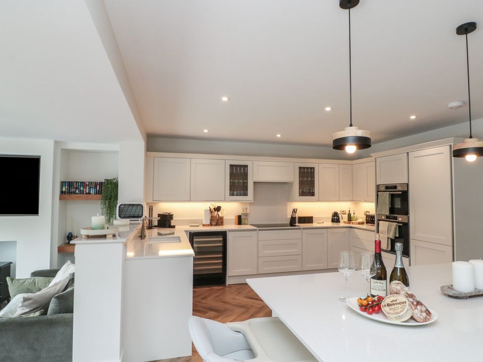 A kitchen with modern appliances and dining area at Puffin Lodge in Hunmanby