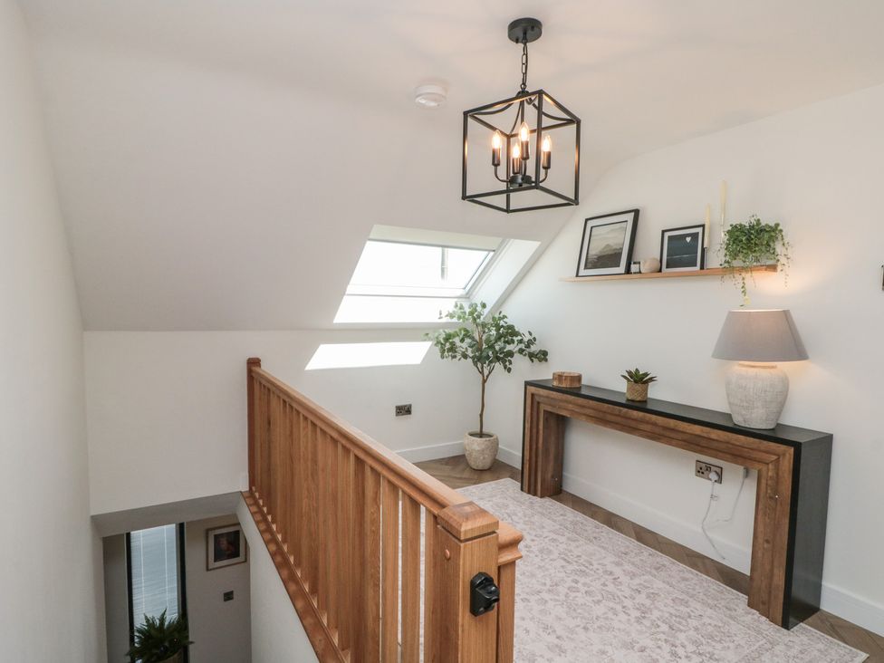 A hallway with a staircase and a console table at Puffin Lodge in Hunmanby
