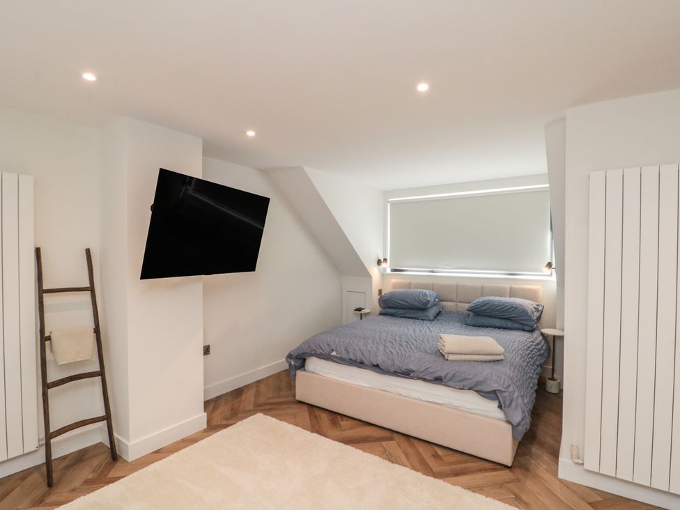 A bedroom with a bed and a television at Puffin Lodge in Hunmanby