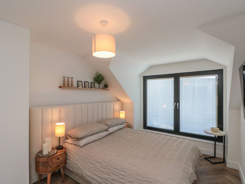 A bedroom with a bed and window at Puffin Lodge in Hunmanby