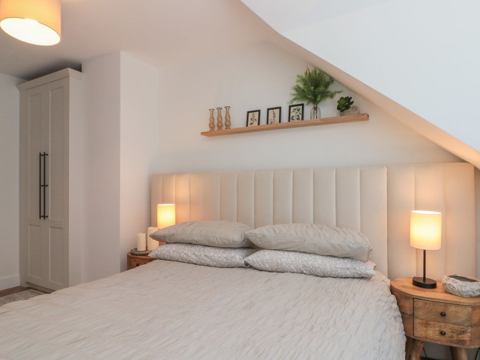 A bedroom with a bed and nightstands at Puffin Lodge in Hunmanby