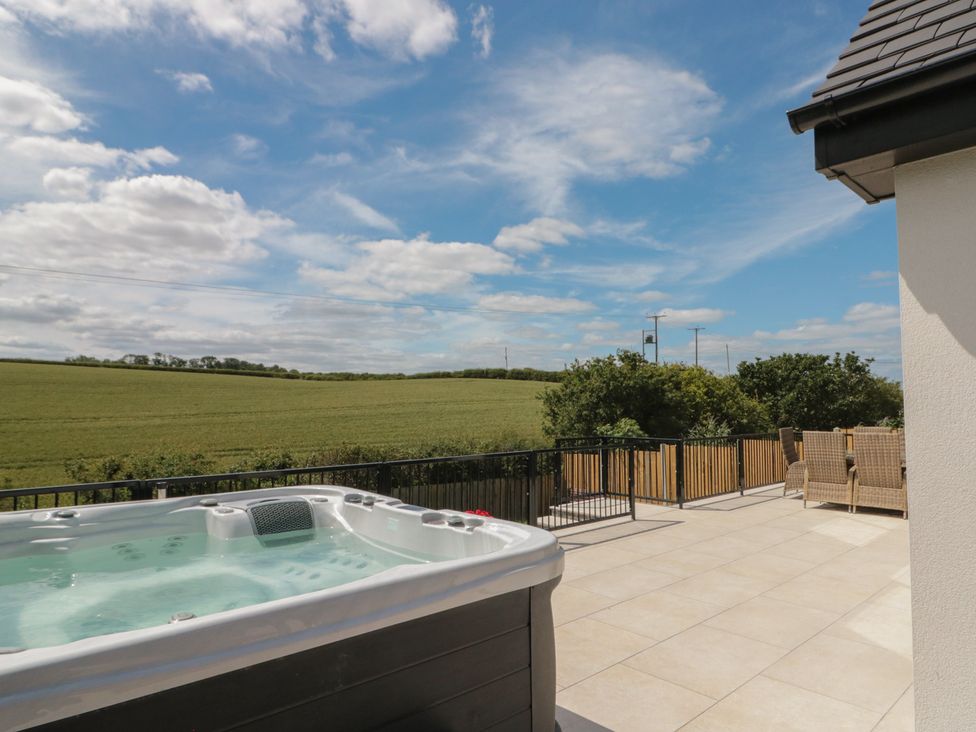 An outdoor area with a hot tub and furniture at Puffin Lodge in Hunmanby