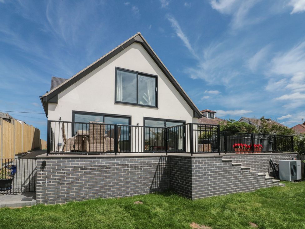 A house with a balcony and outdoor furniture at Puffin Lodge Hunmanby