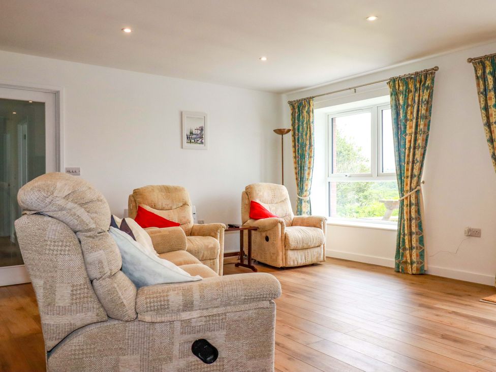A living room with armchairs and a table at Folly View Cambrose near Illogan