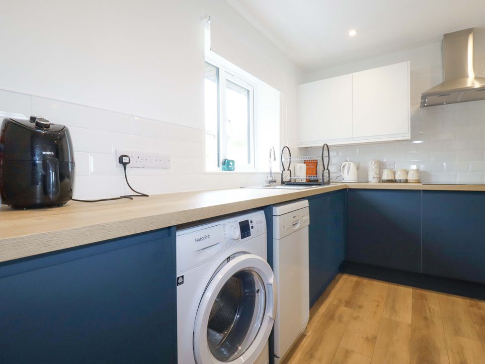 A kitchen with a washing machine and dishwasher at Folly View Cambrose near Illogan