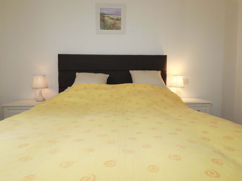 A bedroom with a bed and nightstands at Folly View in Cambrose near Illogan