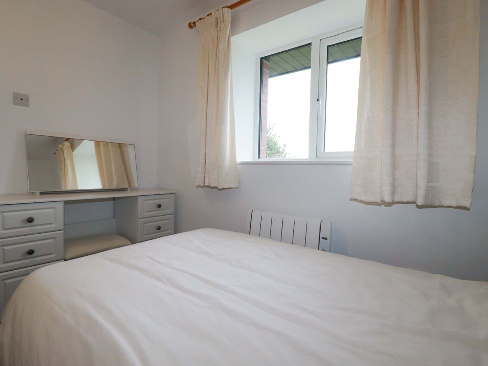 A bedroom with a bed and mirror at Folly View in Cambrose near Illogan