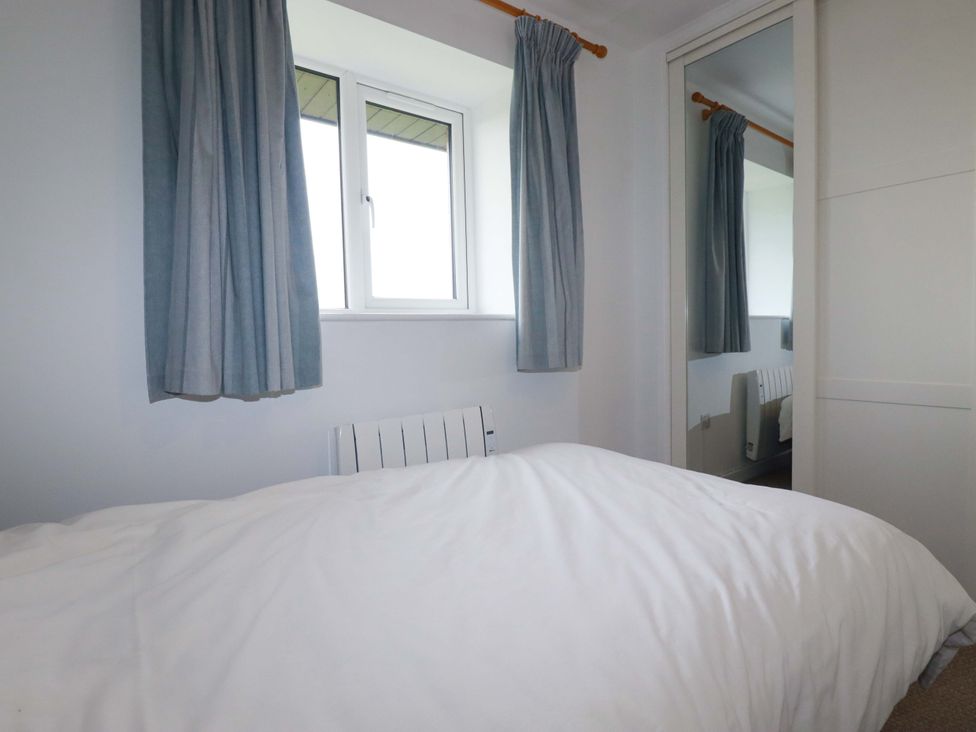 A bedroom with a bed and window at Folly View in Cambrose near Illogan