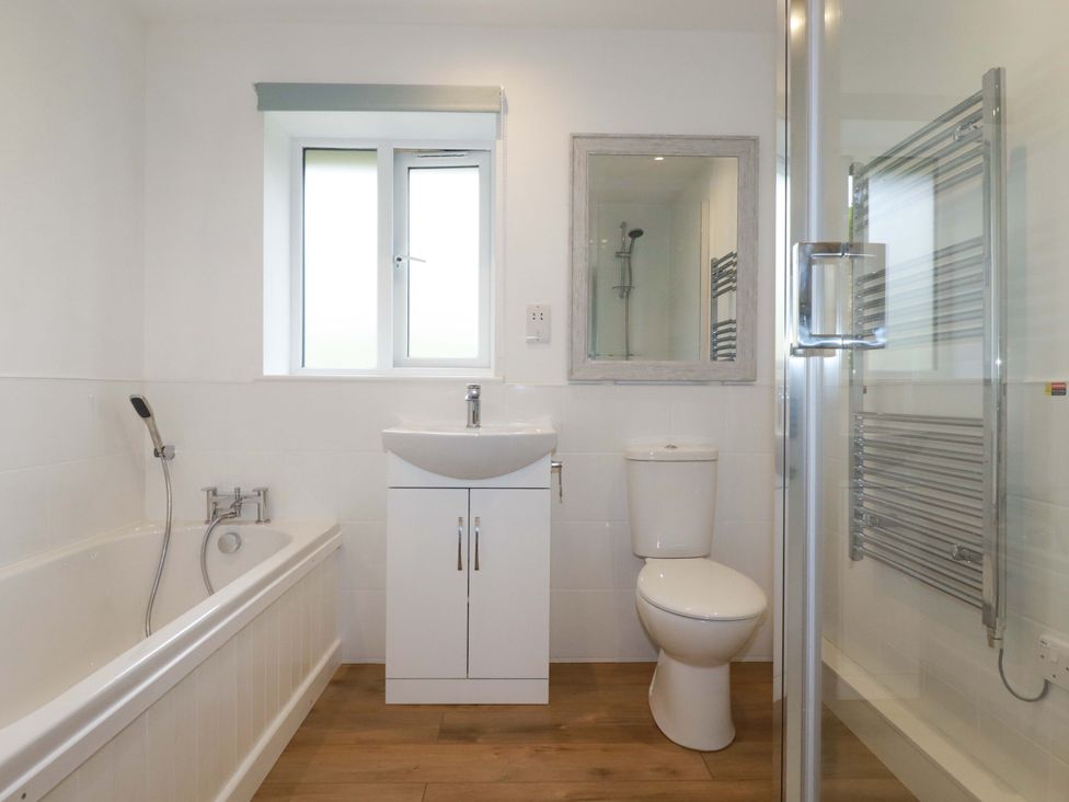 A bathroom with a bathtub, toilet, sink, and shower at Folly View in Cambrose near Illogan