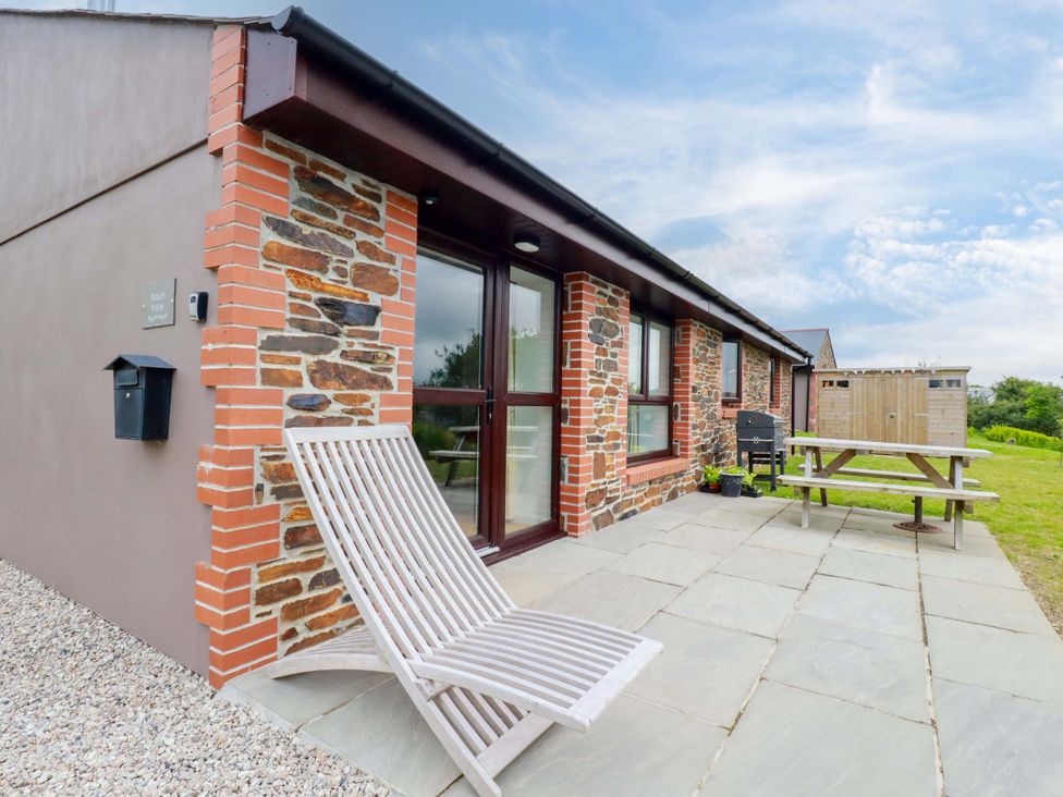 An outdoor area with a picnic table and chair at Folly View Cambrose near Illogan