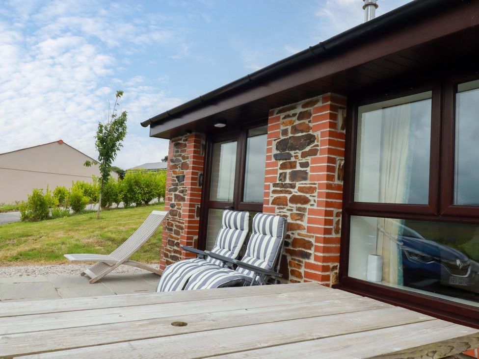 An outdoor area with deck chairs and a wooden table at Folly View in Cambrose near Illogan