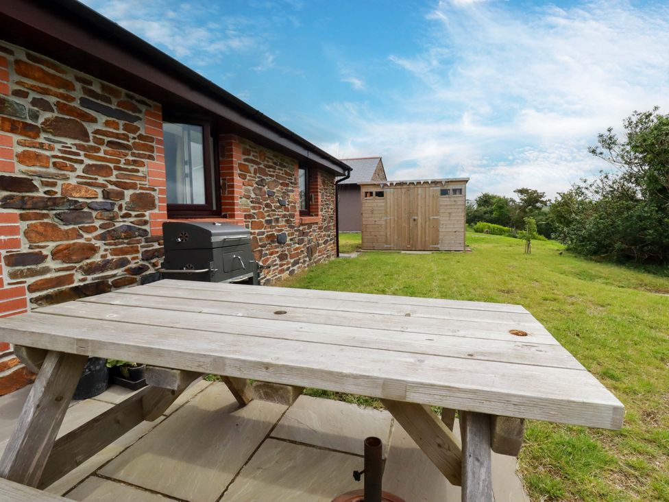 An outdoor area with a table and grill at Folly View in Cambrose near Illogan