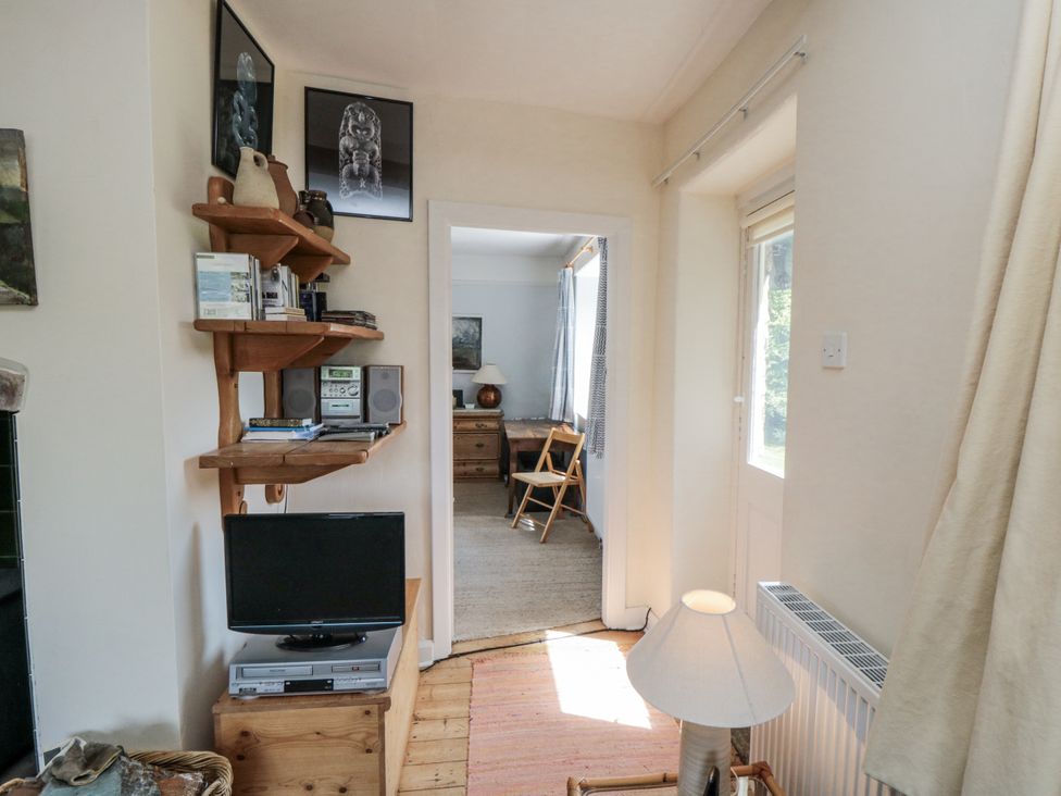 A living room with a television and shelves at Low Muffles Bridge